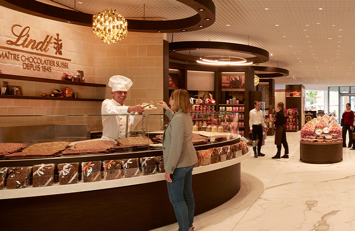 A real Lindt Master Chocolatier inspects a freshly made chocolate bar